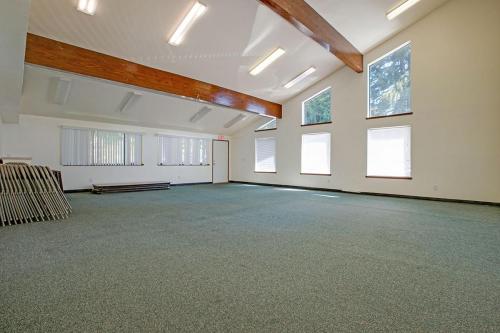 An empty room with wood beams and windows.